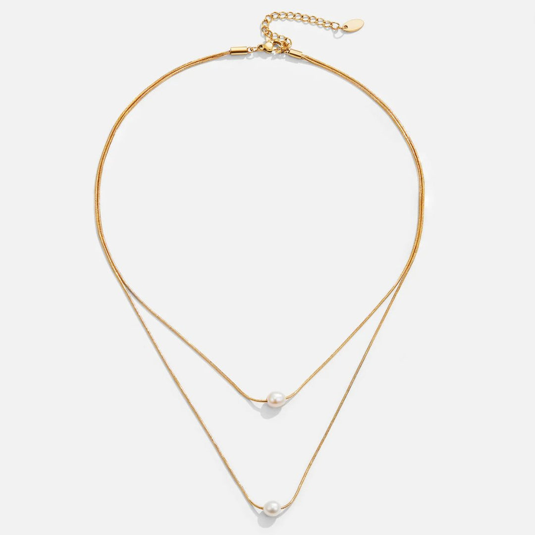 Sabine – Two-layer gold chain with a dark stone.
