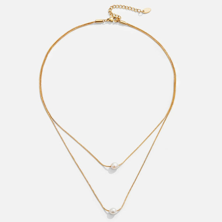 Sabine – Two-layer gold chain with a dark stone.