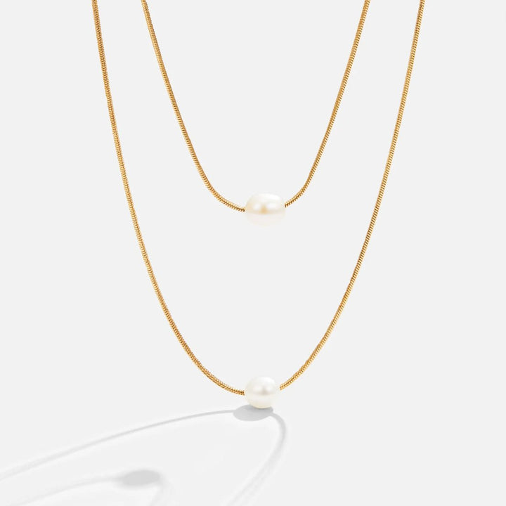 Sabine – Two-layer gold chain with a dark stone.