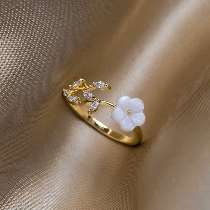 Miriam – An engagement ring adorned with white floral decorations.