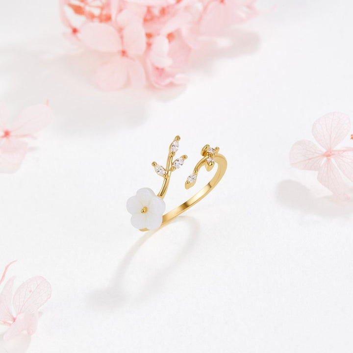 Miriam – An engagement ring adorned with white floral decorations.